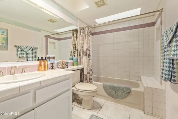 a bathroom with a sink a toilet a mirror and shower