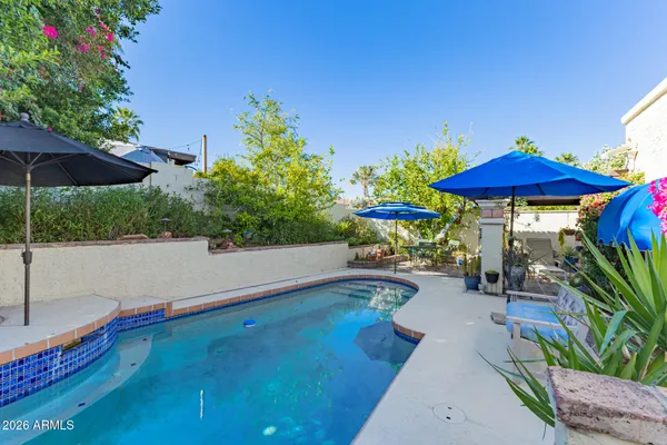 a view of a patio with chairs under an umbrella