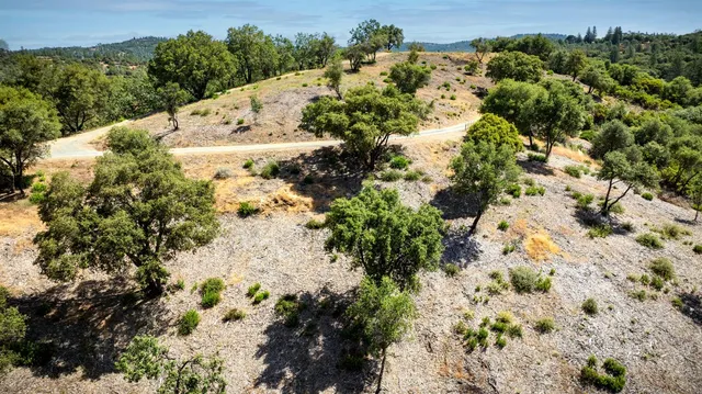 an aerial view of house with yard and mountain view in back