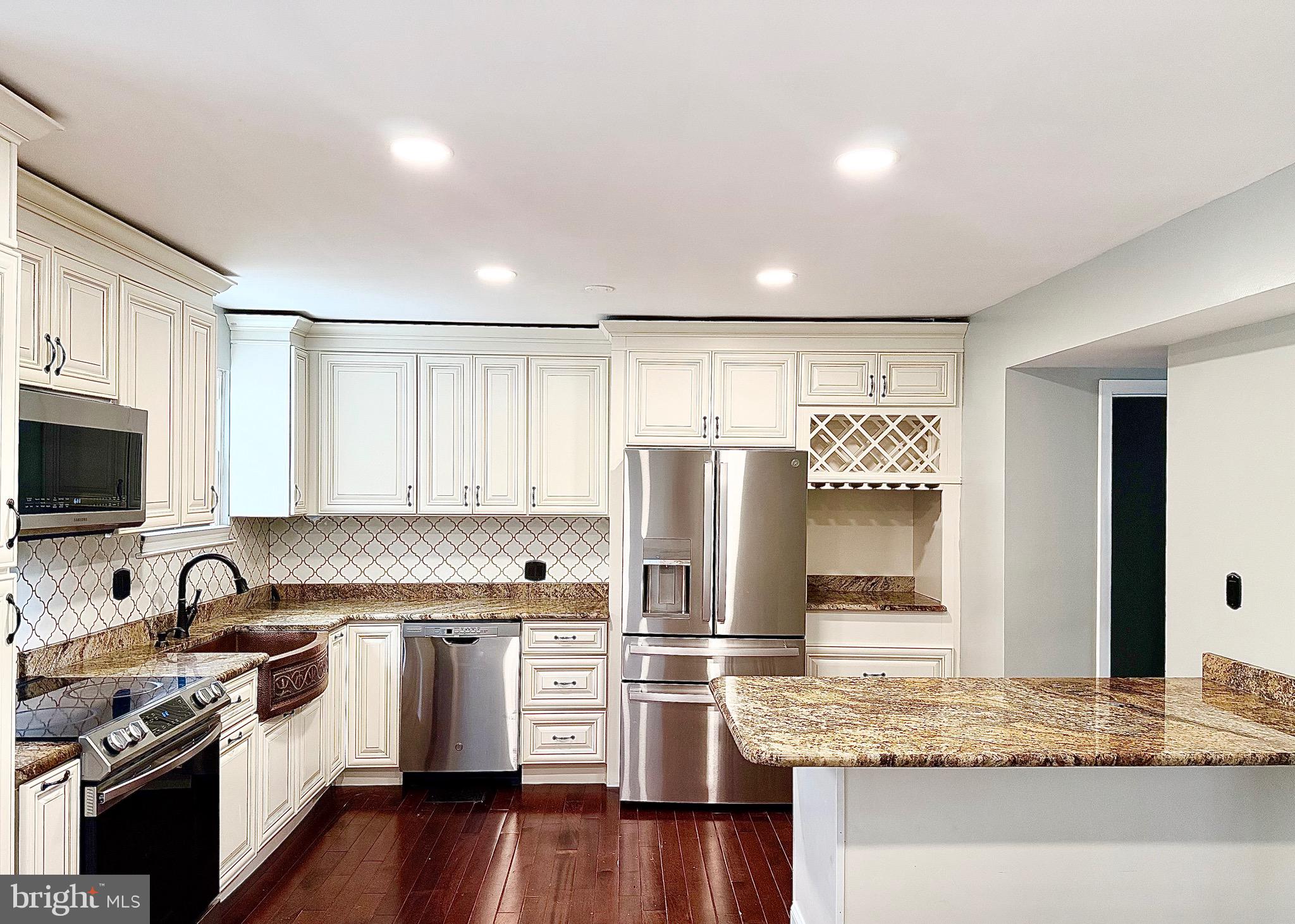 1 Broadleaf Court Baltimore, MD 21234 - Photo 8 of 35 a kitchen with granite countertop a refrigerator stove and sink with wooden floor