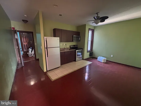 a kitchen with a refrigerator and a stove top oven