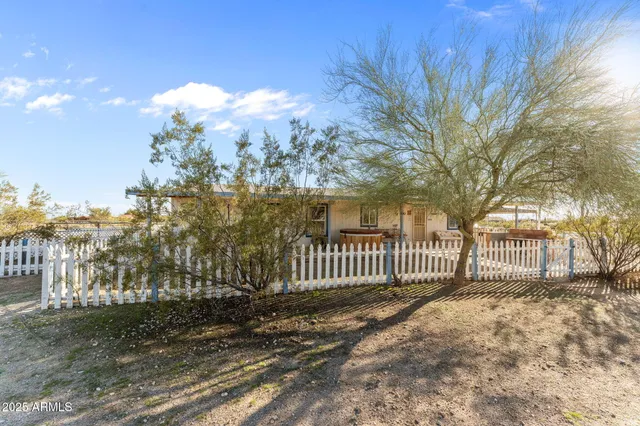 a view of a yard with wooden fence