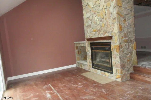 a view of empty room with a fireplace