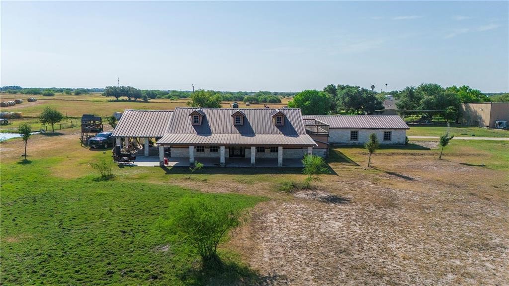 an aerial view of a house with big yard and large trees