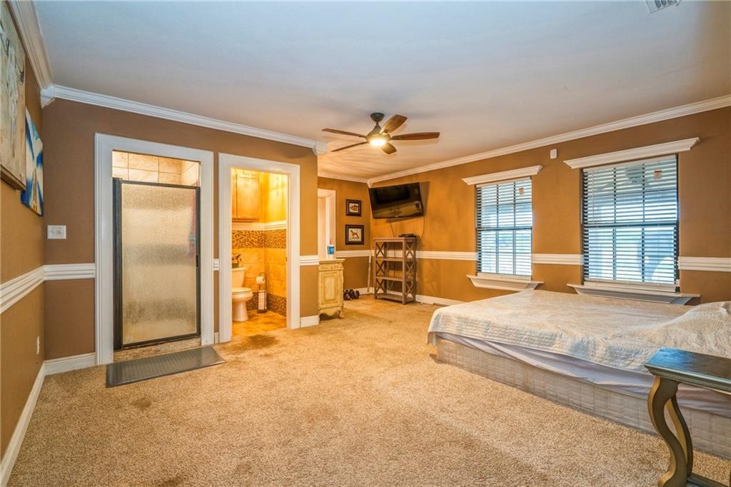 7084 Bartosch Road Robstown, TX 78380 - Photo 15 of 35 a spacious bedroom with a bed a table and large windows