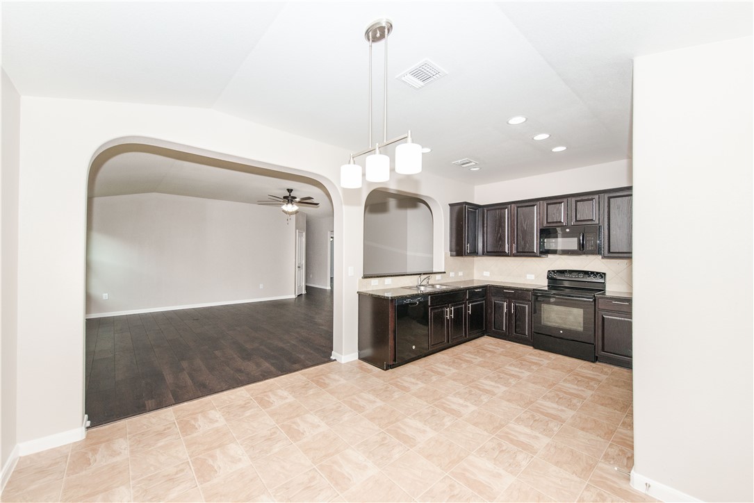 1007 Plateau Trail Georgetown, TX 78626 - Photo 26 of 32 a large kitchen with granite countertop a lot of cabinets and stainless steel appliances