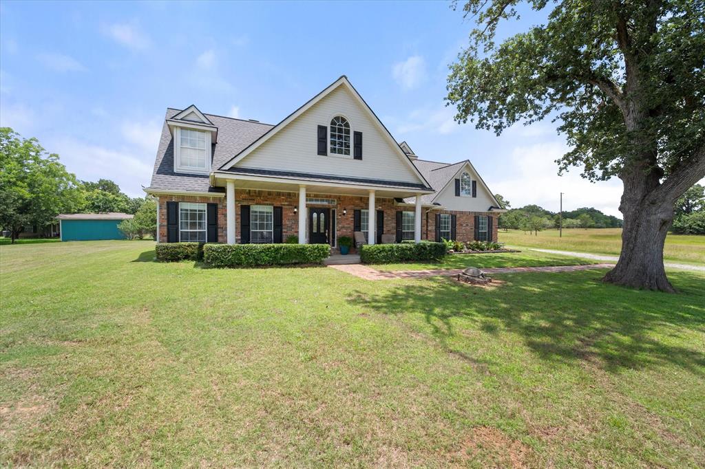 13021 Rudy's Way Streetman, TX 75859 - Photo 39 of 40 Front exterior near Dallas with brick curb appeal, covered porch, mature shade tree, and welcoming walkway.