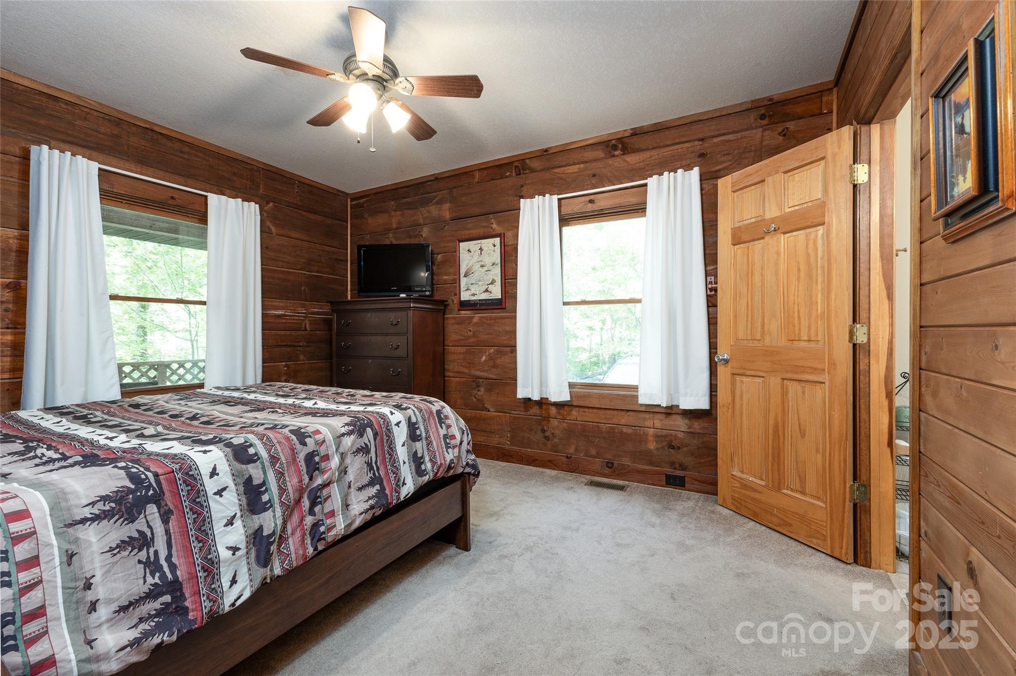 242 Eagles Roost Road Bryson City, NC 28713 - Photo 16 of 33 a bedroom with a large bed and a chandelier fan