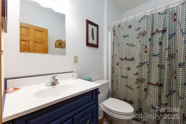 a bathroom with a sink mirror vanity and toilet