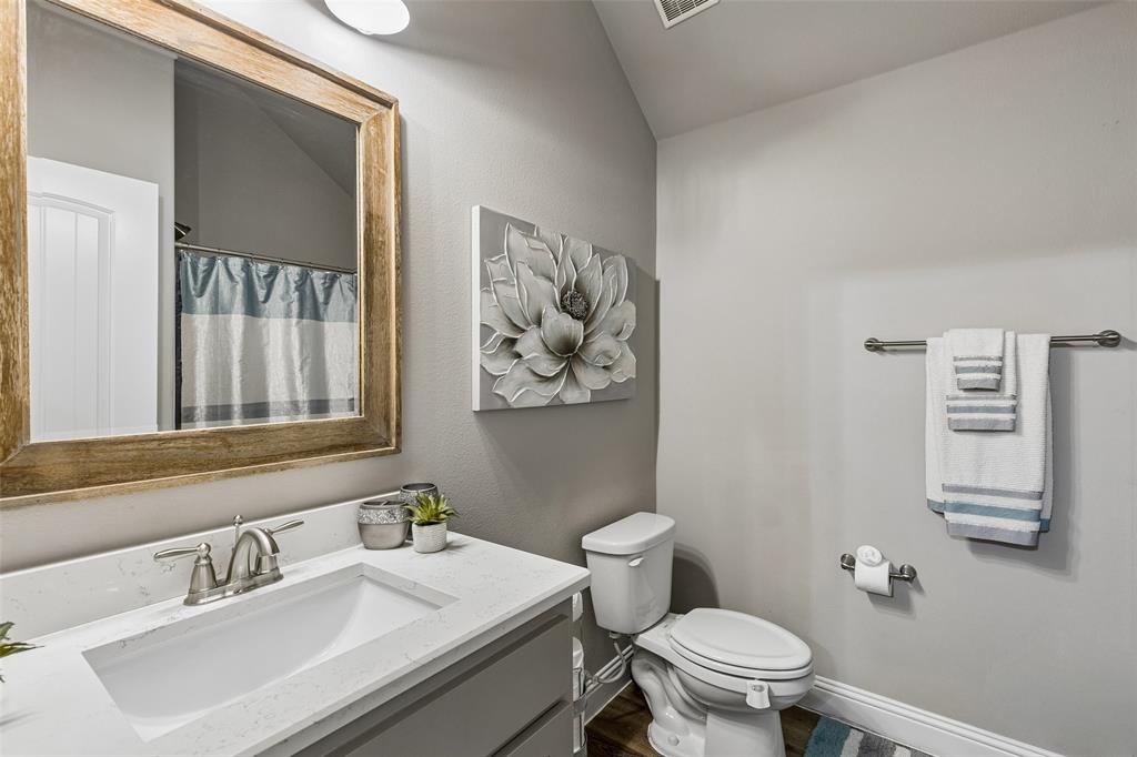 108 Maverick Lane Pilot Point, TX 76258 - Photo 23 of 27 Bathroom featuring a wide vanity with a rectangular undermount sink, a chrome two-handle faucet, and a large wood-framed mirror