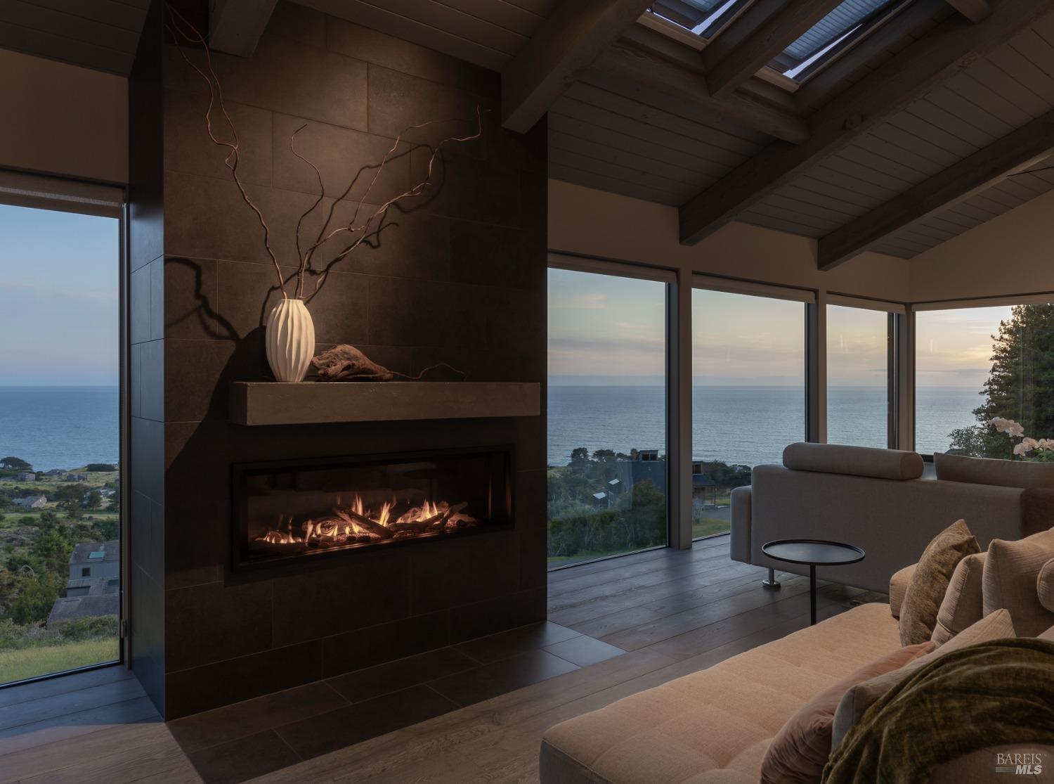 Undisclosed Address The Sea Ranch, CA 95497 - Photo 9 of 46 a living room with furniture a fireplace and a floor to ceiling window