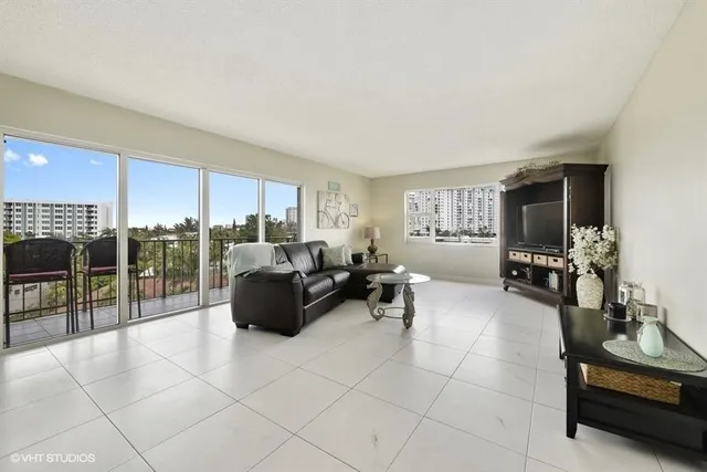 a living room with furniture a flat screen tv and a table