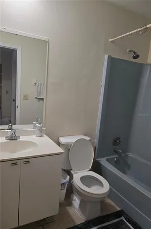 a bathroom with a toilet a sink and mirror