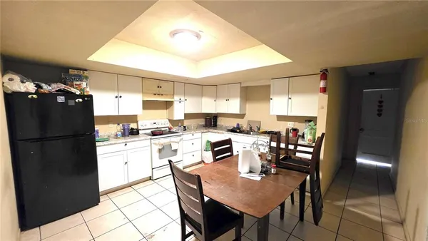 a kitchen with refrigerator and chairs