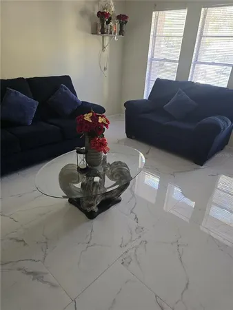 a living room with furniture flowerpot and a window