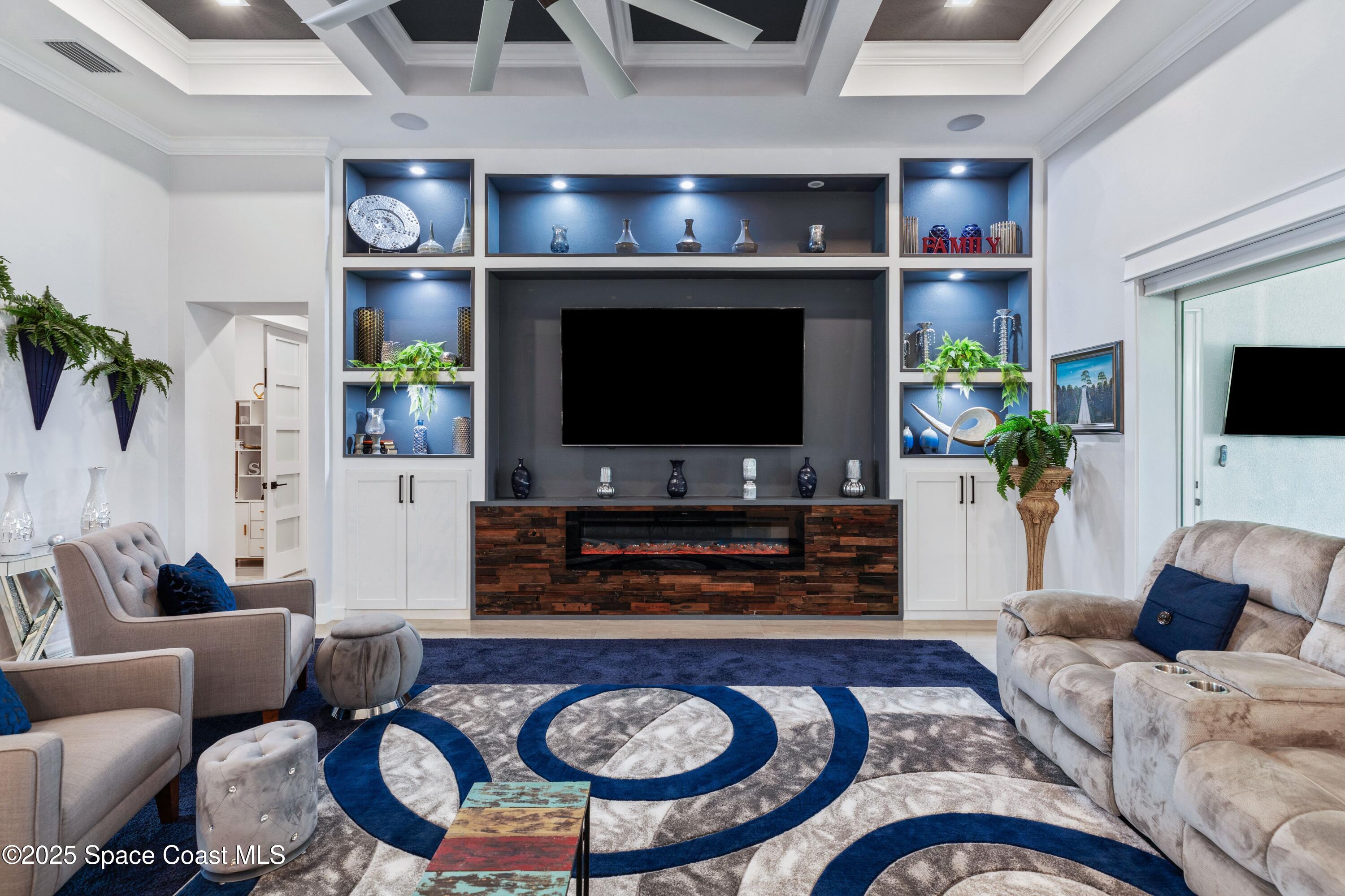 1420 Corey Road Malabar, FL 32950 - Photo 16 of 35 a living room with furniture a flat screen tv and a fireplace