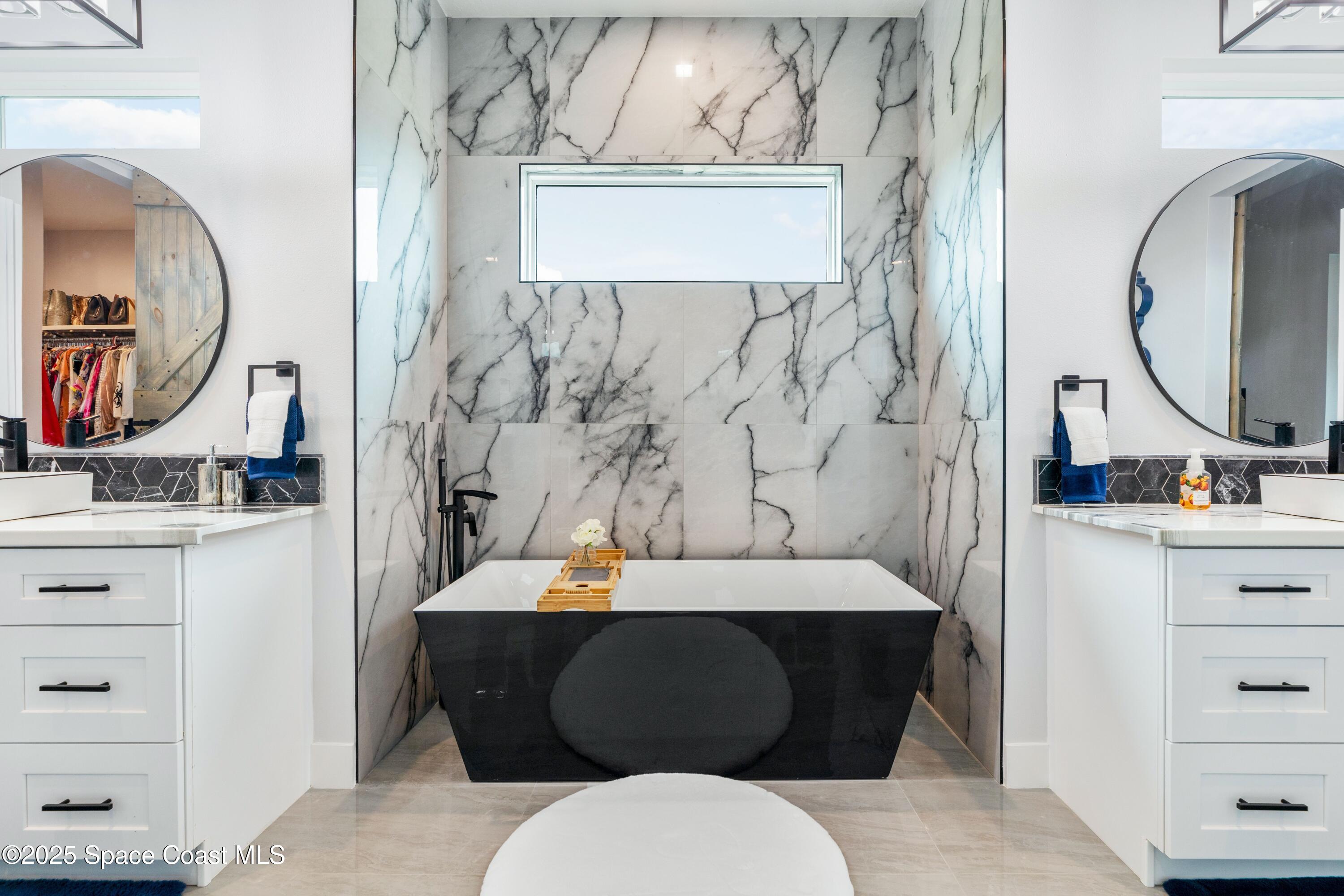 1420 Corey Road Malabar, FL 32950 - Photo 21 of 35 a bathroom with a bathtub sink and mirror