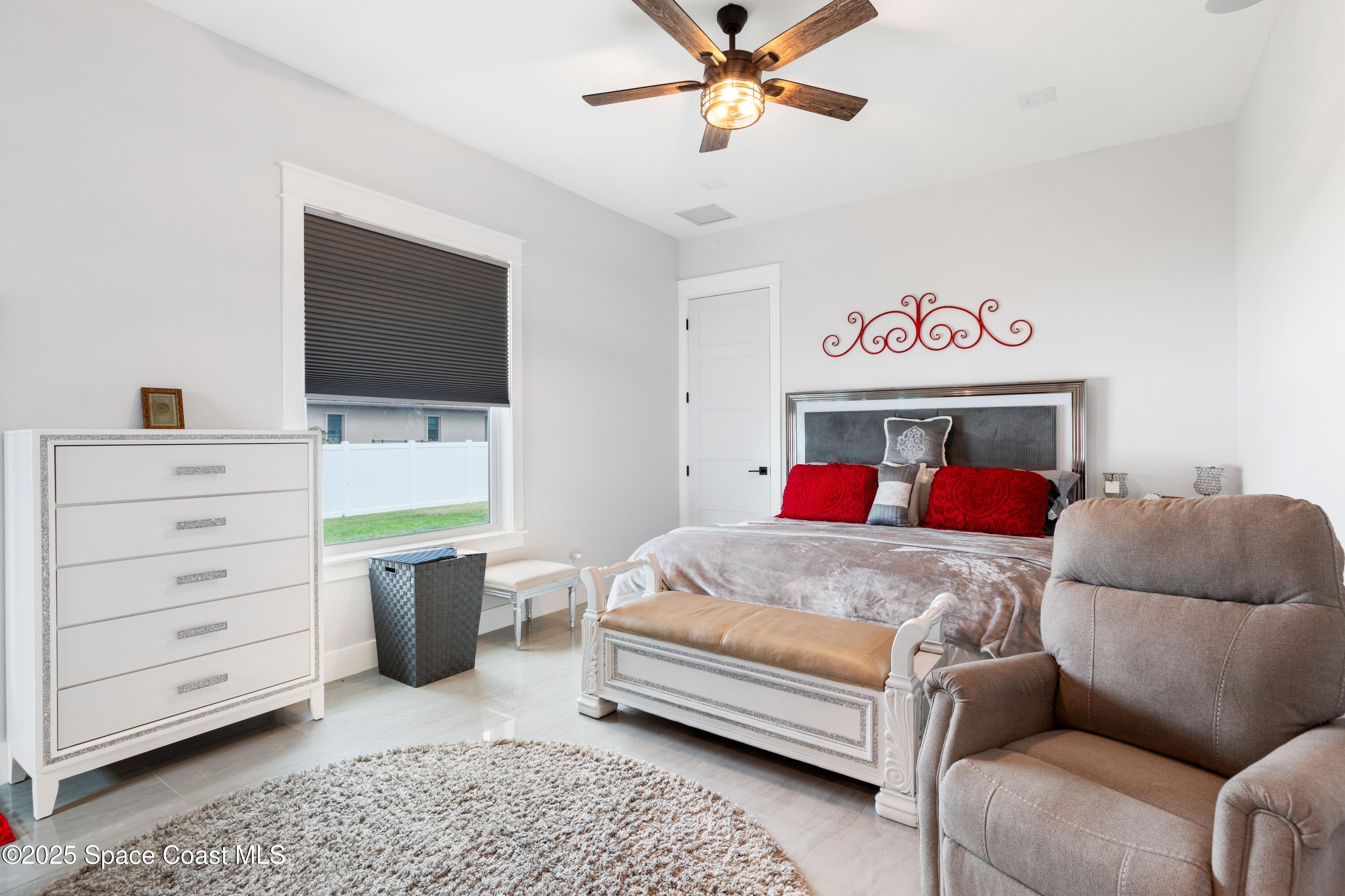 1420 Corey Road Malabar, FL 32950 - Photo 25 of 35 a bedroom with a bed a couch and a flat screen television