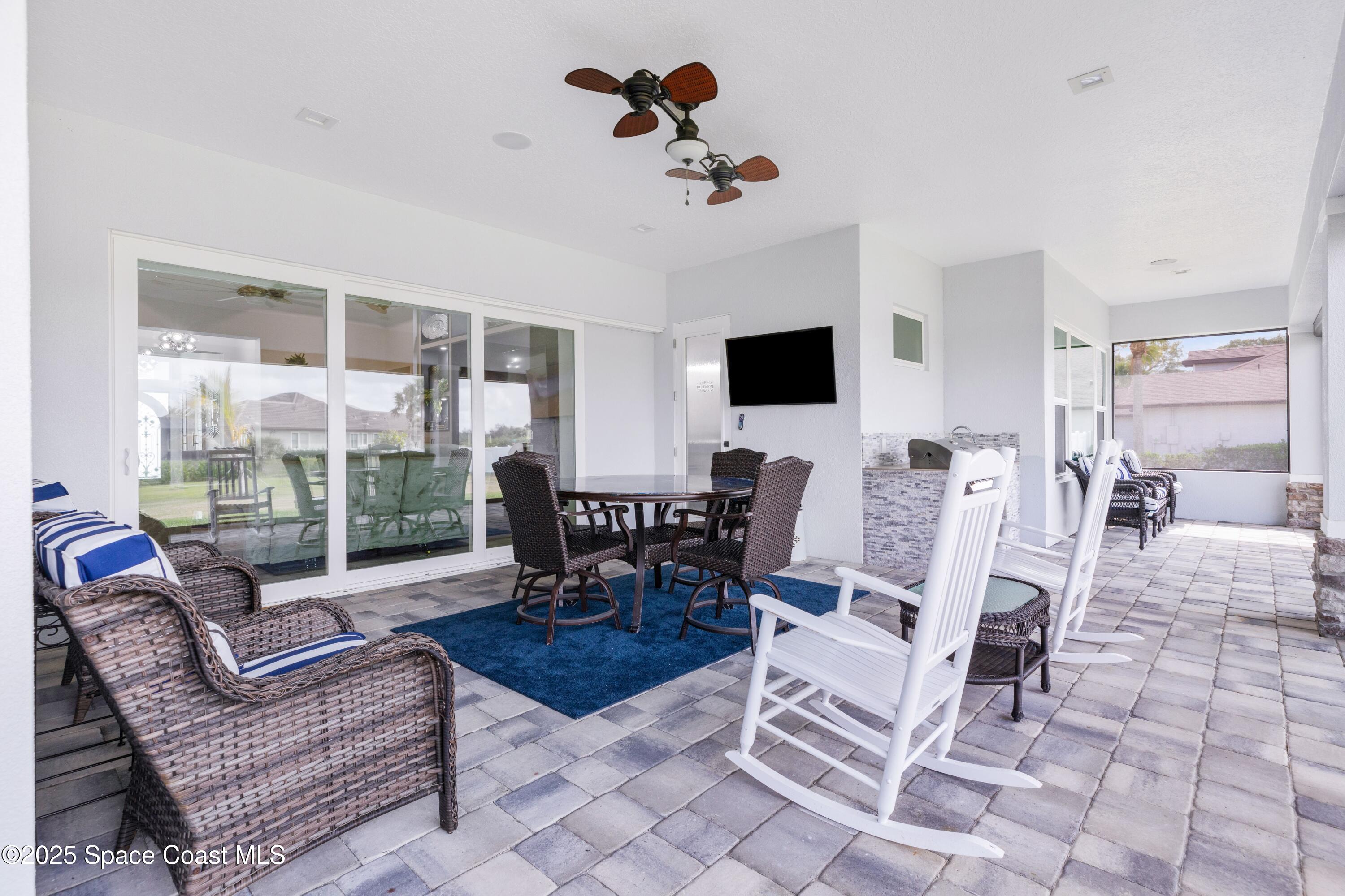 1420 Corey Road Malabar, FL 32950 - Photo 27 of 35 a living room with patio chairs and a flat screen tv