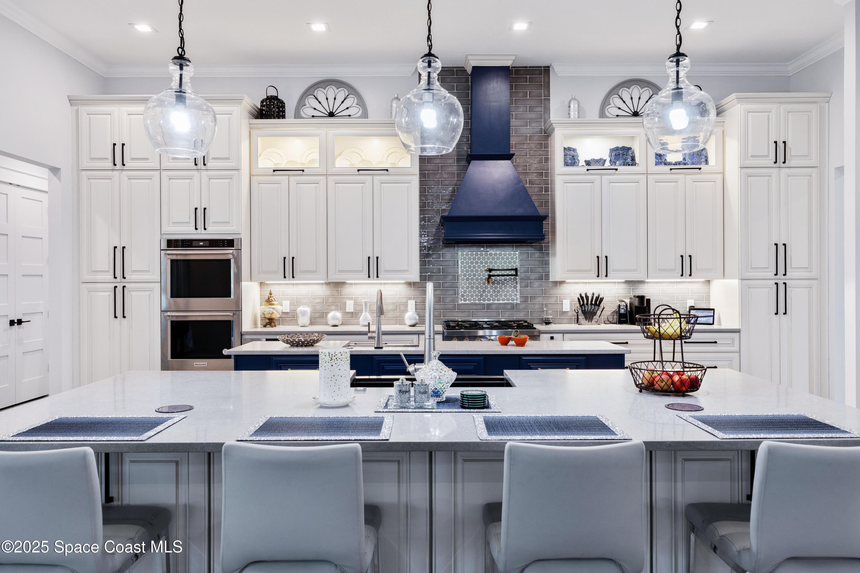 1420 Corey Road Malabar, FL 32950 - Photo 10 of 35 a kitchen with stainless steel appliances a table chairs in it and wooden floors