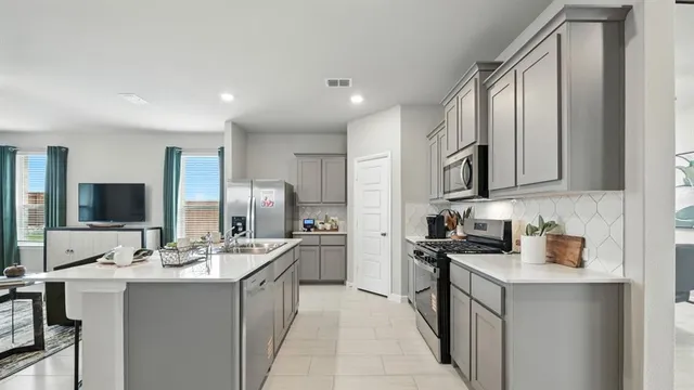 a kitchen with kitchen island a sink stove and refrigerator