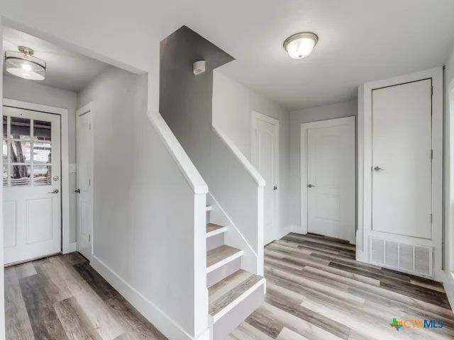 a view of a hallway with wooden floor and entryway