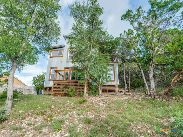 an aerial view of residential houses with outdoor space and ocean view