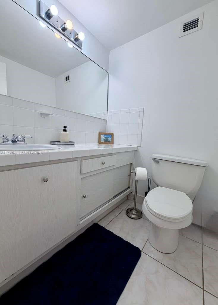 100 Lincoln Road, Unit 541 Miami Beach, FL 33139 - Photo 14 of 17 a bathroom with a toilet a sink and mirror