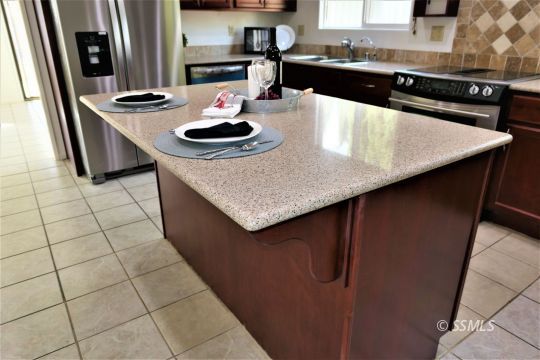 337 Larkspur Street Ridgecrest, CA 93555 - Photo 18 of 38 a kitchen with stainless steel appliances granite countertop a sink a stove and a microwave