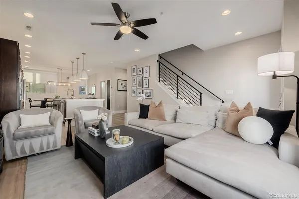 a living room with furniture and a ceiling fan