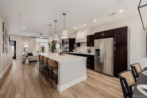 a kitchen with kitchen island a refrigerator a stove a sink dishwasher with a dining table and chairs