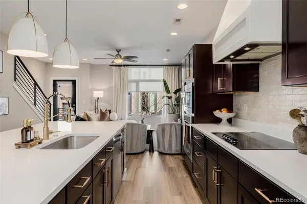 a kitchen with white cabinets a sink dishwasher and a stove with wooden floor
