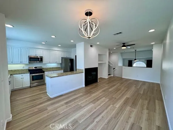 a kitchen with stainless steel appliances granite countertop a sink stove microwave and refrigerator