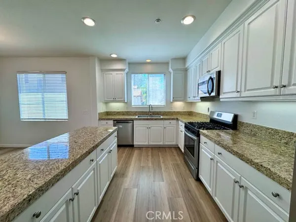 a kitchen with granite countertop white cabinets and white appliances