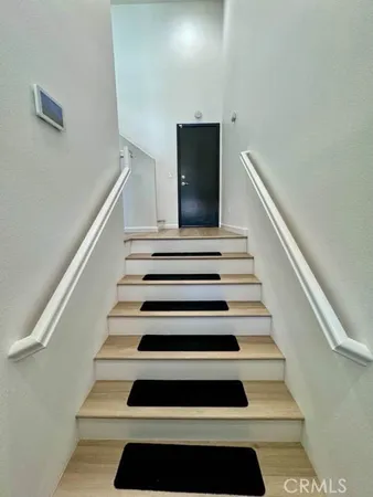 a view of a hallway with wooden floor and a living room