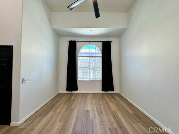 a view of hallway with a window and wooden floor