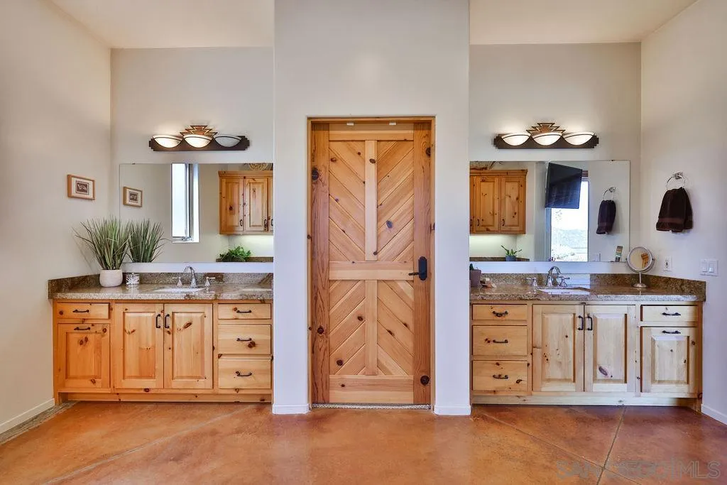15775 Castle Peak Lane Jamul, CA 91935 - Photo 29 of 56 a spacious bathroom with a granite countertop sink and a mirror