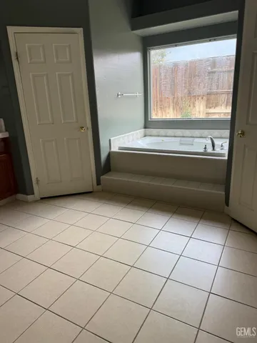 a bathroom with a bathtub and next to a window