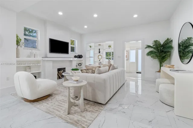 a living room with furniture a flat screen tv and a fireplace