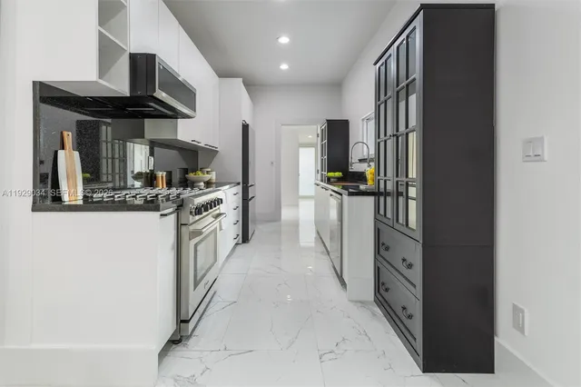 a kitchen with stainless steel appliances granite countertop a refrigerator and a stove