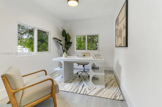 a view of a workspace with furniture and a window