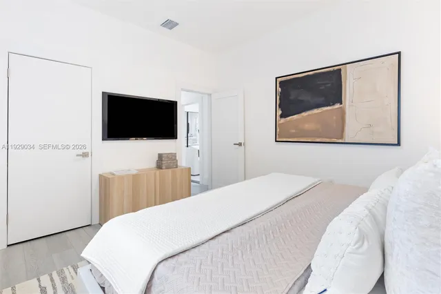 a bedroom with a bed and a flat screen tv