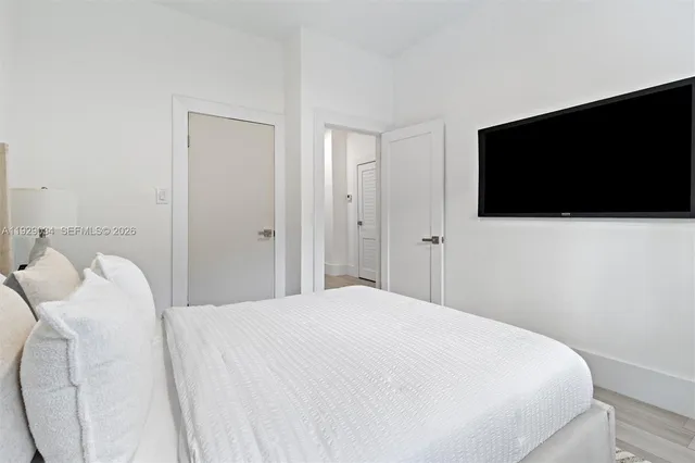 a bedroom with a bed and a flat screen tv