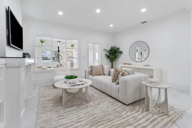 a living room with furniture a clock and a flat screen tv