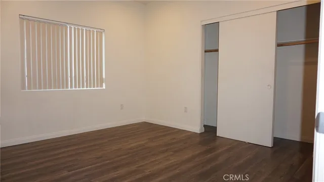 an empty room with wooden floor and a window