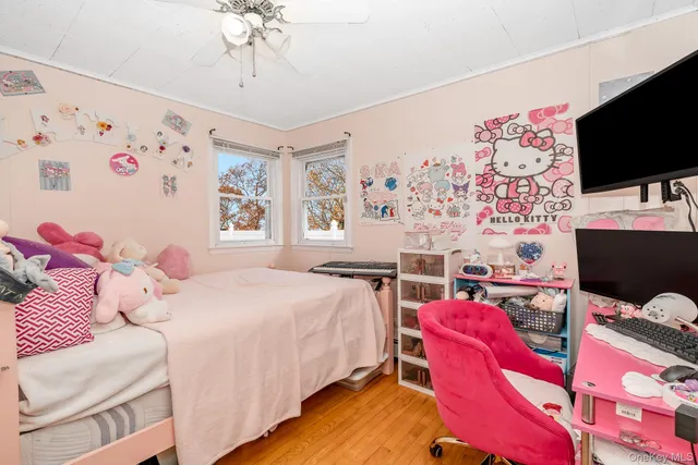 a bedroom with a bed and a flat tv screen on the dresser