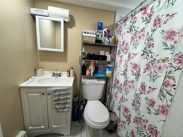 a bathroom with a granite countertop toilet and a sink