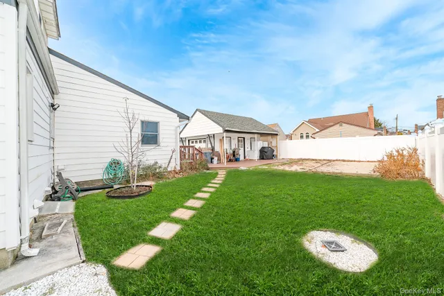 a view of a white house in front of a yard