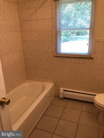 a bathroom with a bathtub and a window