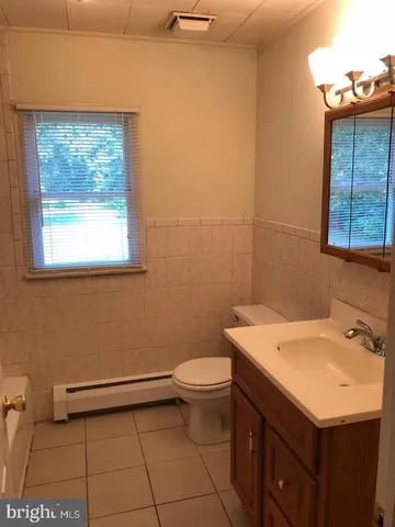a bathroom with a sink a toilet and a window